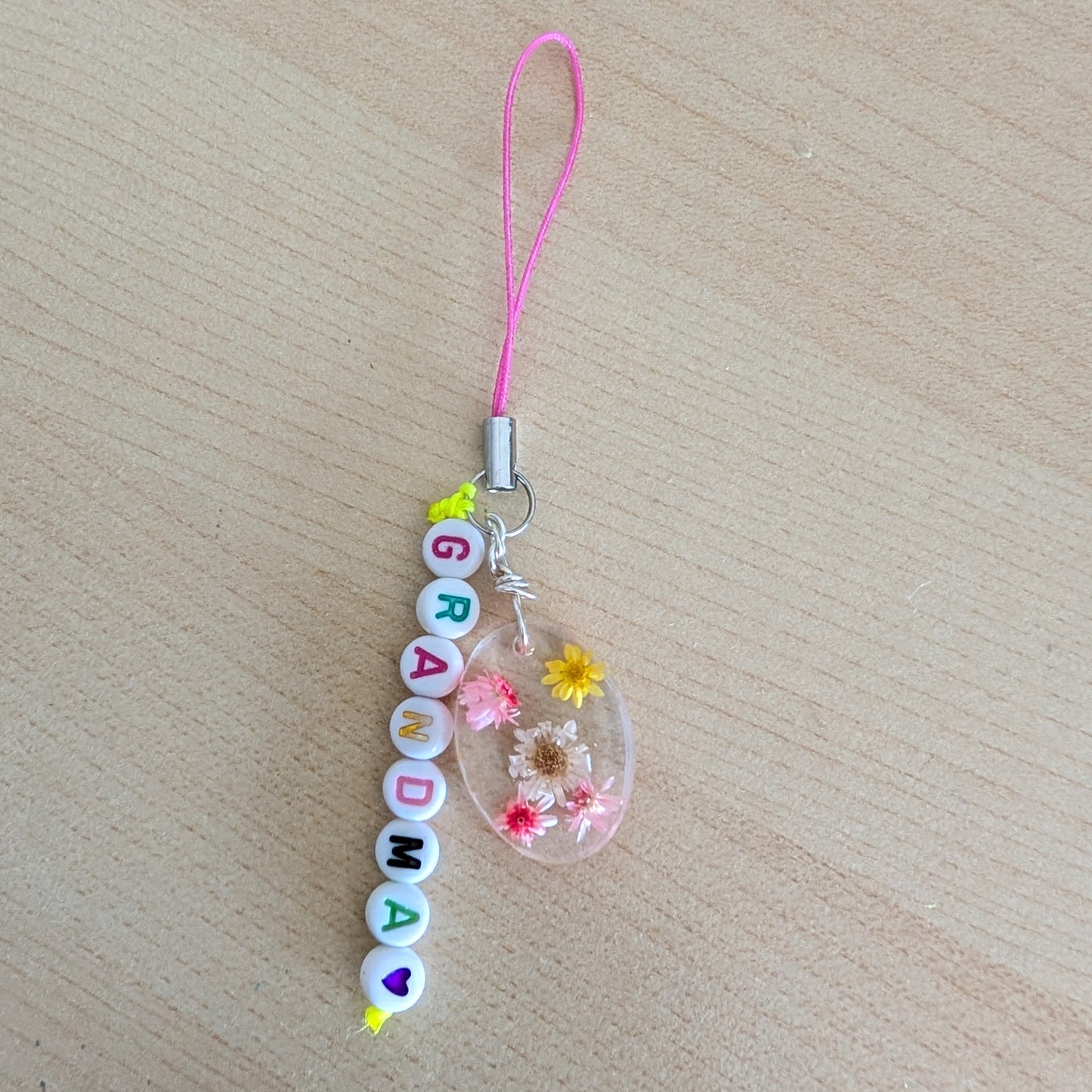 Spice up your phone with this charming resin charm, adorned with real dried flowers and beads. The 3.75 inch length adds a touch of flair to any device. (It's like a bouquet, but for your phone!)

Phone charm - Resin charm with dried flowers and beads