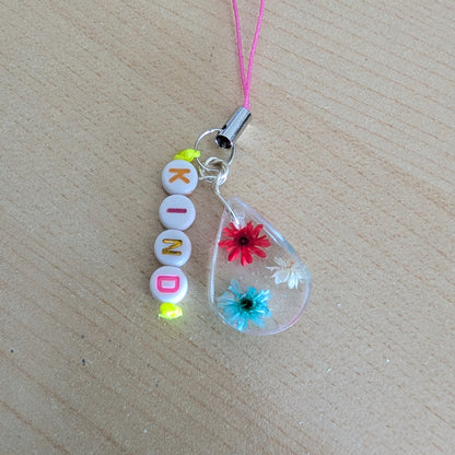 Spice up your phone with this charming resin charm, adorned with real dried flowers and beads. The 3.75 inch length adds a touch of flair to any device. (It's like a bouquet, but for your phone!)

Phone charm - Resin charm with dried flowers and beads