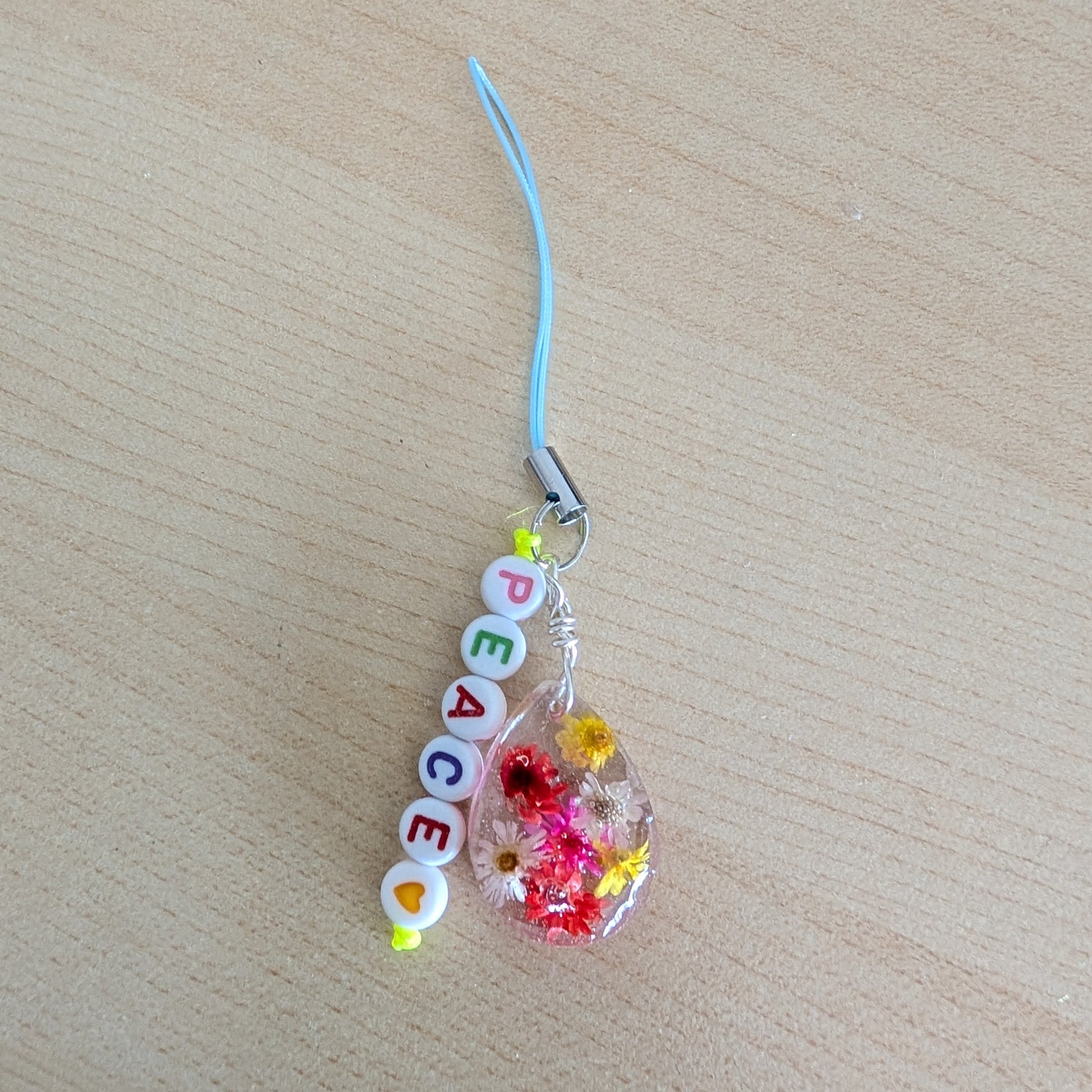 Spice up your phone with this charming resin charm, adorned with real dried flowers and beads. The 3.75 inch length adds a touch of flair to any device. (It's like a bouquet, but for your phone!)

Phone charm - Resin charm with dried flowers and beads
