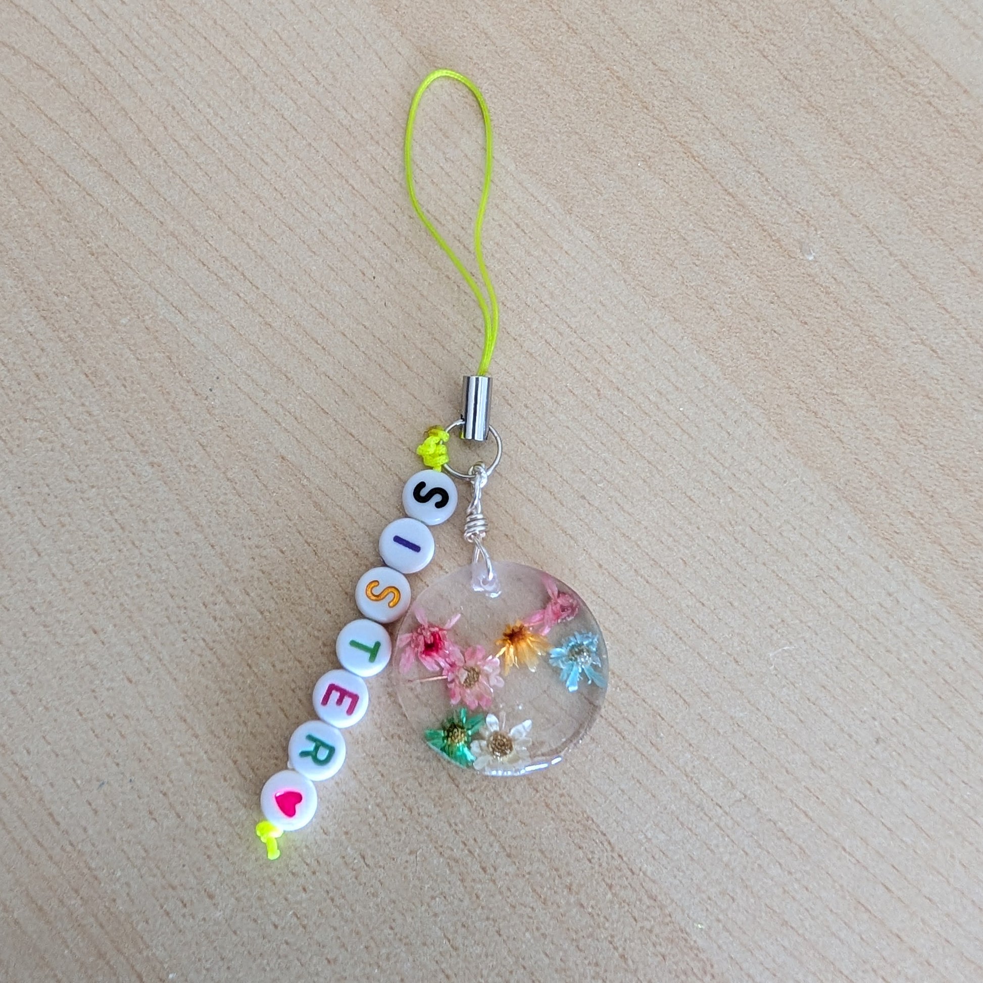 Spice up your phone with this charming resin charm, adorned with real dried flowers and beads. The 3.75 inch length adds a touch of flair to any device. (It's like a bouquet, but for your phone!)

Phone charm - Resin charm with dried flowers and beads