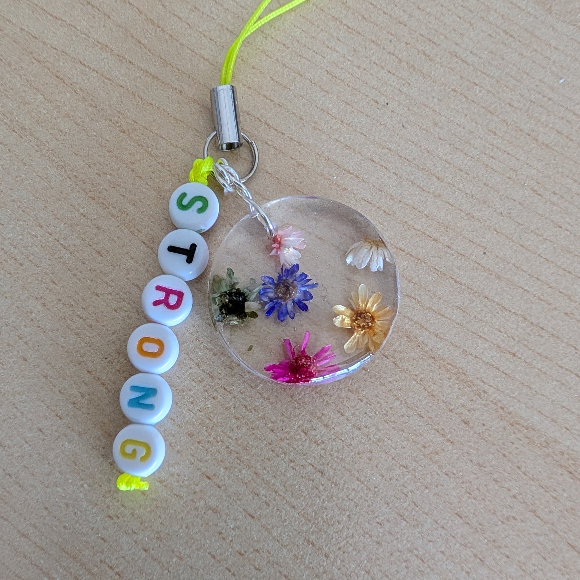Spice up your phone with this charming resin charm, adorned with real dried flowers and beads. The 3.75 inch length adds a touch of flair to any device. (It's like a bouquet, but for your phone!)

Phone charm - Resin charm with dried flowers and beads