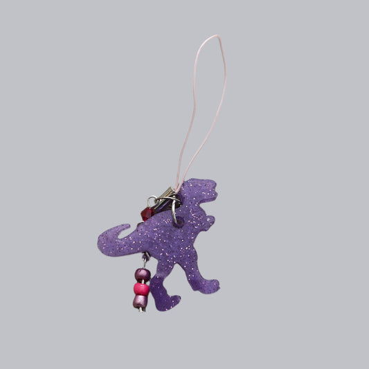 Add some roar to your phone with this T-Rex-resin dinosaur charm! With colorful beads for extra pizzazz, this charm will have everyone dino-swooning over your phone. Don't let your phone be extinct of style - grab this charm today!