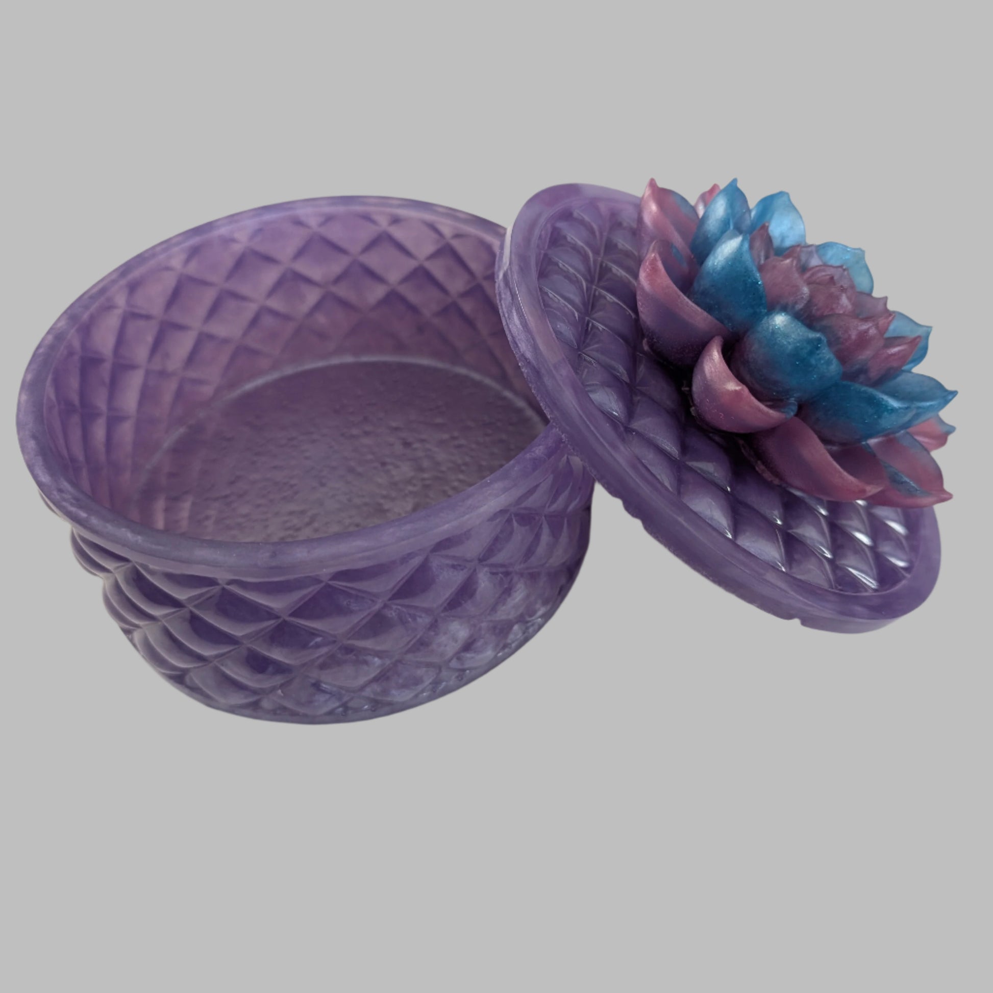 Keep your tiniest treasures safe in our round trinket box. With a charming resin design and a beautiful flower lid, it adds a playful touch to any space. At approximately 5 x 5 in, 4.25 in height, and weighing 11.7 oz, it's perfect for your precious items.