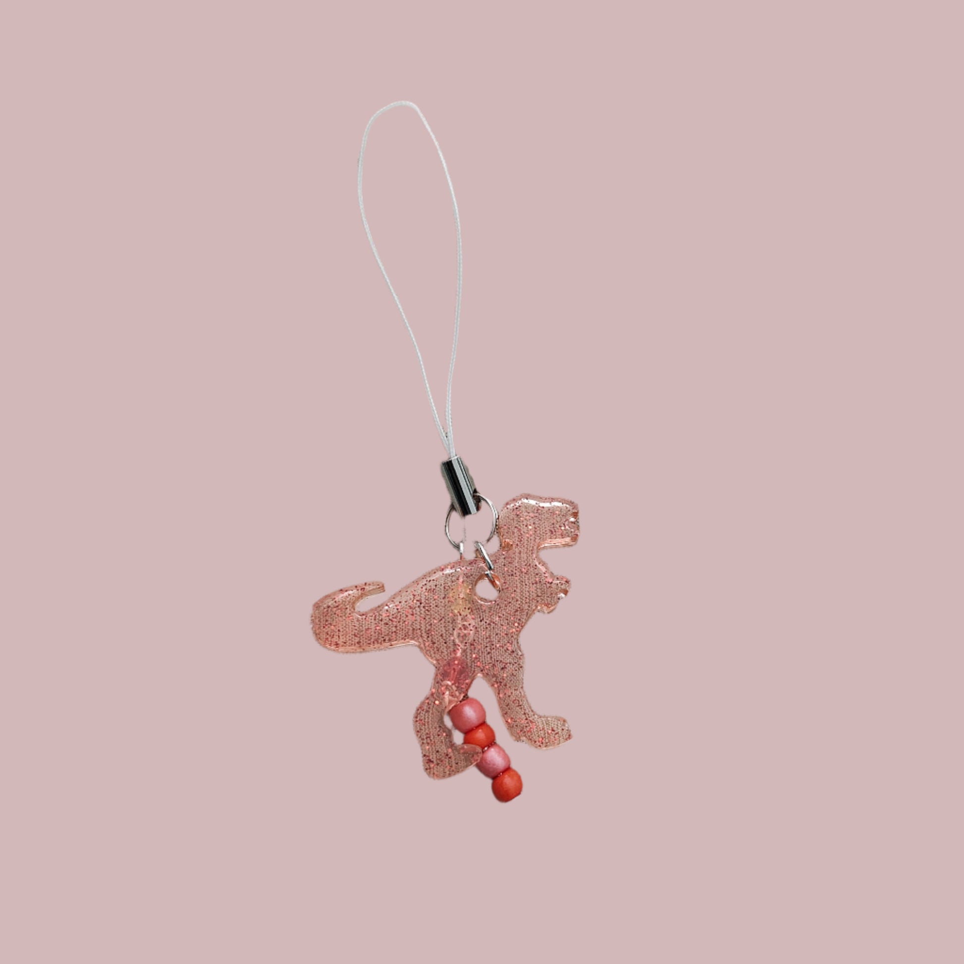 Add some roar to your phone with this T-Rex-resin dinosaur charm! With colorful beads for extra pizzazz, this charm will have everyone dino-swooning over your phone. Don't let your phone be extinct of style - grab this charm today!