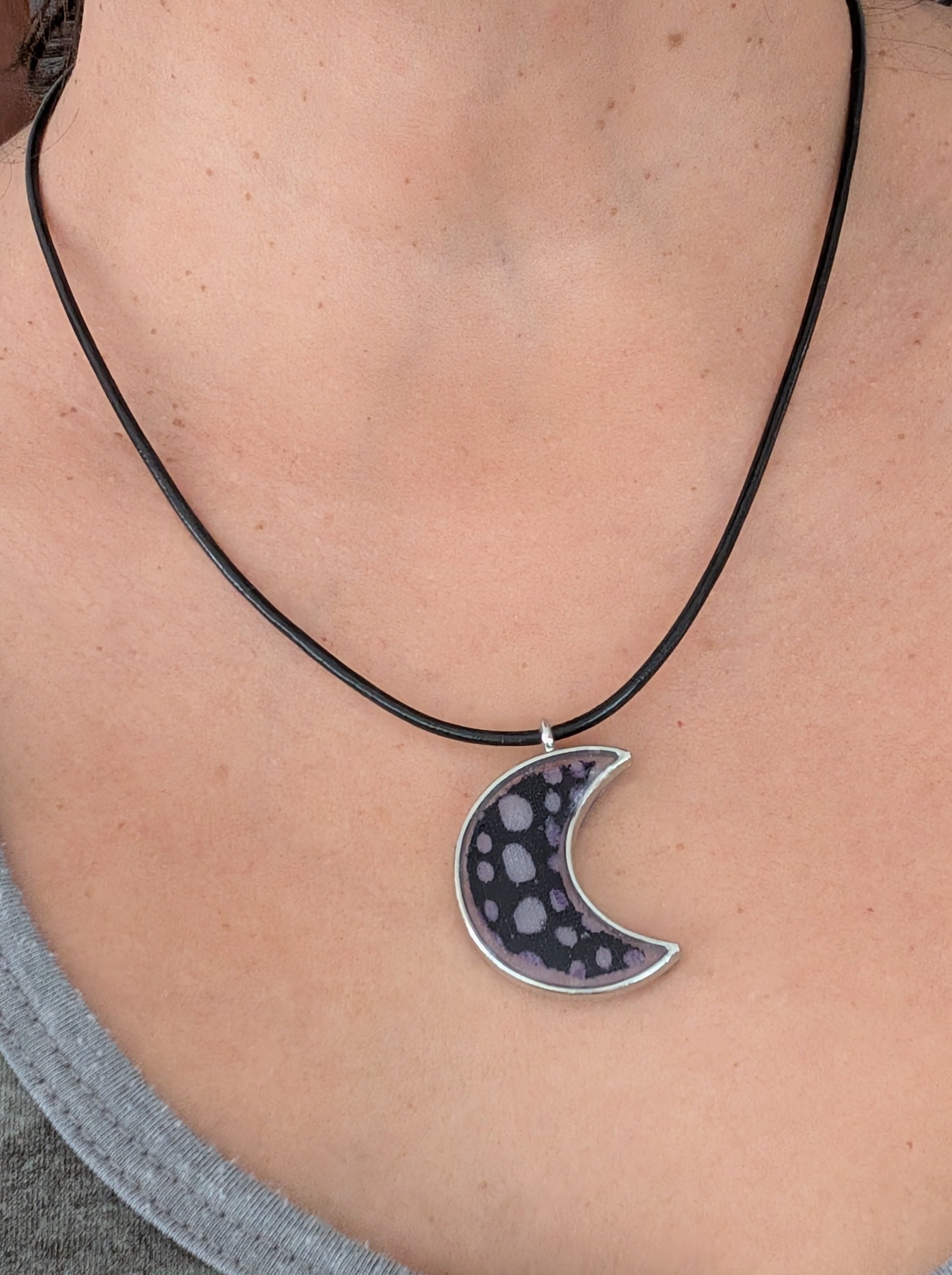 This stunning necklace features an 18-inch black leather cord with a resin silver moon pendant. The extension chain adds an extra 2 inches for the perfect fit. Lightweight at only 0.2 oz, this necklace will elevate any outfit. Feel passionate and inspired wearing this beautiful piece.