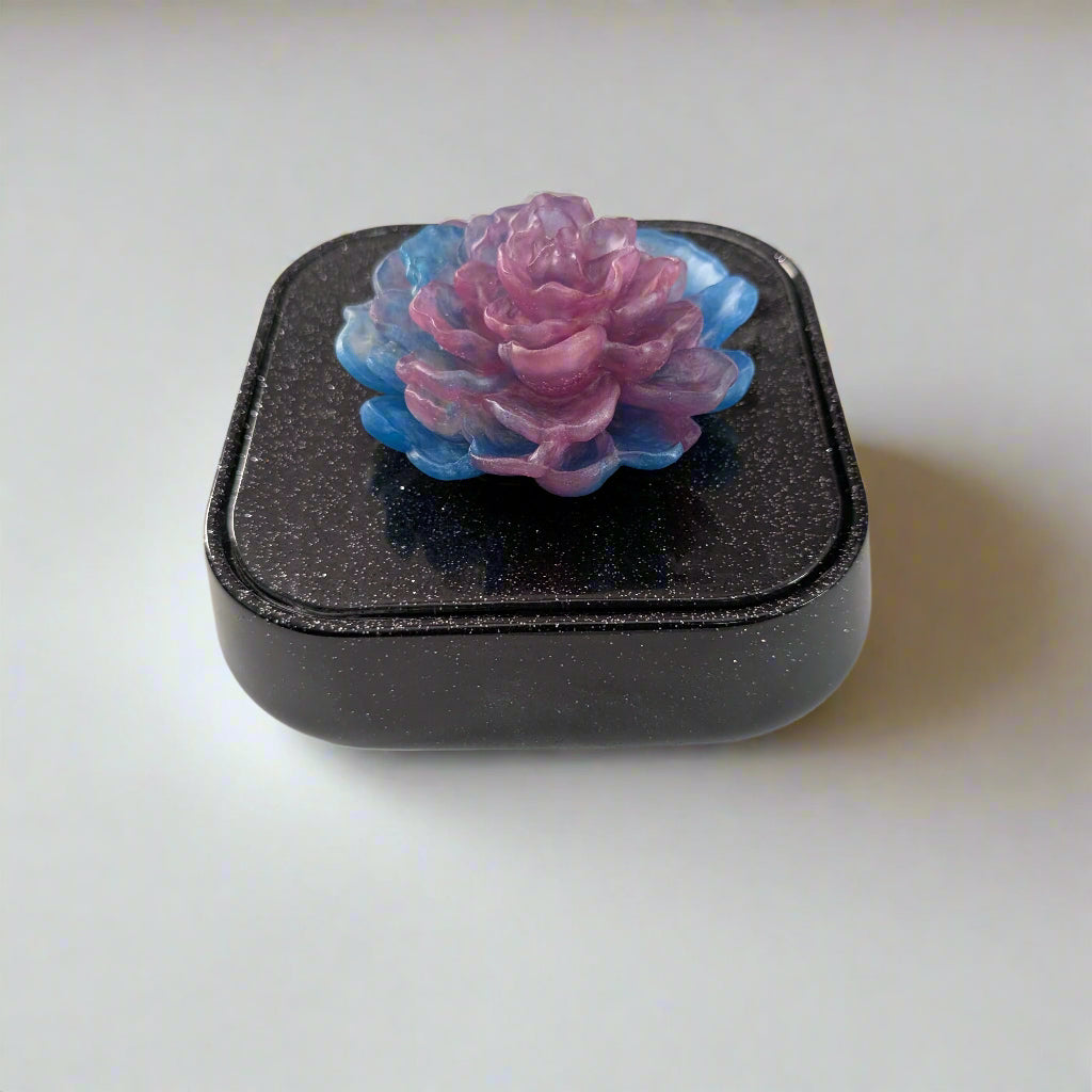 Elevate your jewelry collection with this stunning Knickknack jewelry box. Featuring a flower lid and made of durable resin, this box measures 5 x 5 inches and has a depth of 1.5 inches, making it perfect for large pieces. Weighing only 14 oz, it's also lightweight and easy to transport. Transform your dressing table and protect your precious pieces with this beautiful box.