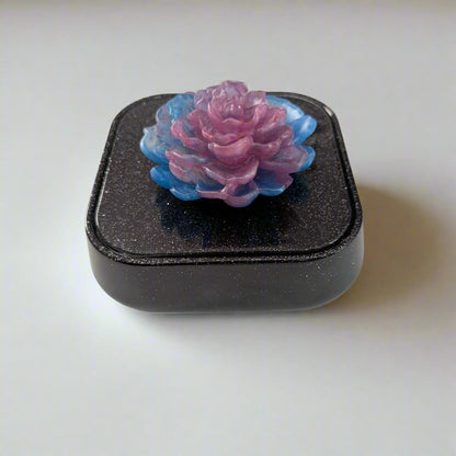 Elevate your jewelry collection with this stunning Knickknack jewelry box. Featuring a flower lid and made of durable resin, this box measures 5 x 5 inches and has a depth of 1.5 inches, making it perfect for large pieces. Weighing only 14 oz, it's also lightweight and easy to transport. Transform your dressing table and protect your precious pieces with this beautiful box.