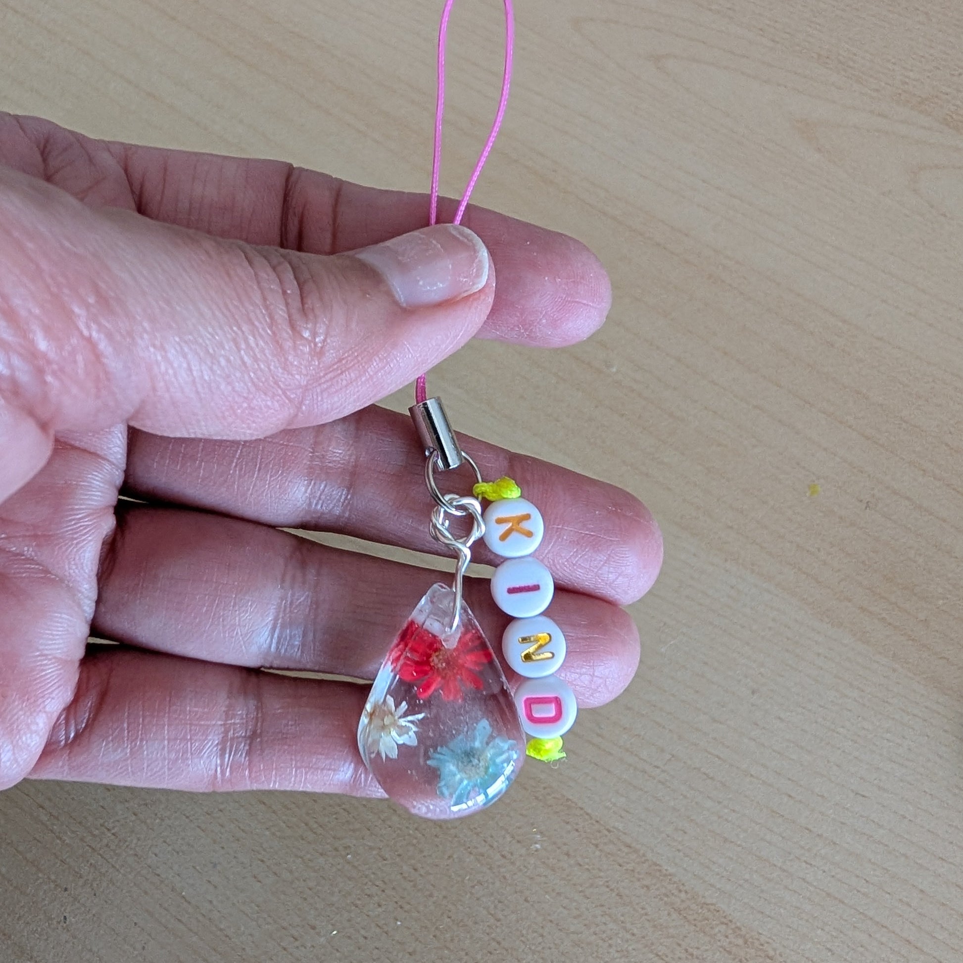 Spice up your phone with this charming resin charm, adorned with real dried flowers and beads. The 3.75 inch length adds a touch of flair to any device. (It's like a bouquet, but for your phone!)

Phone charm - Resin charm with dried flowers and beads