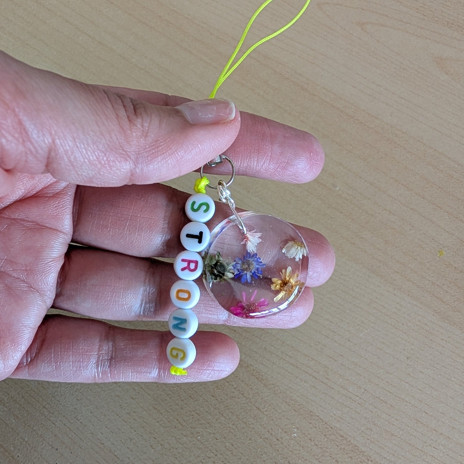 Spice up your phone with this charming resin charm, adorned with real dried flowers and beads. The 3.75 inch length adds a touch of flair to any device. (It's like a bouquet, but for your phone!)

Phone charm - Resin charm with dried flowers and beads