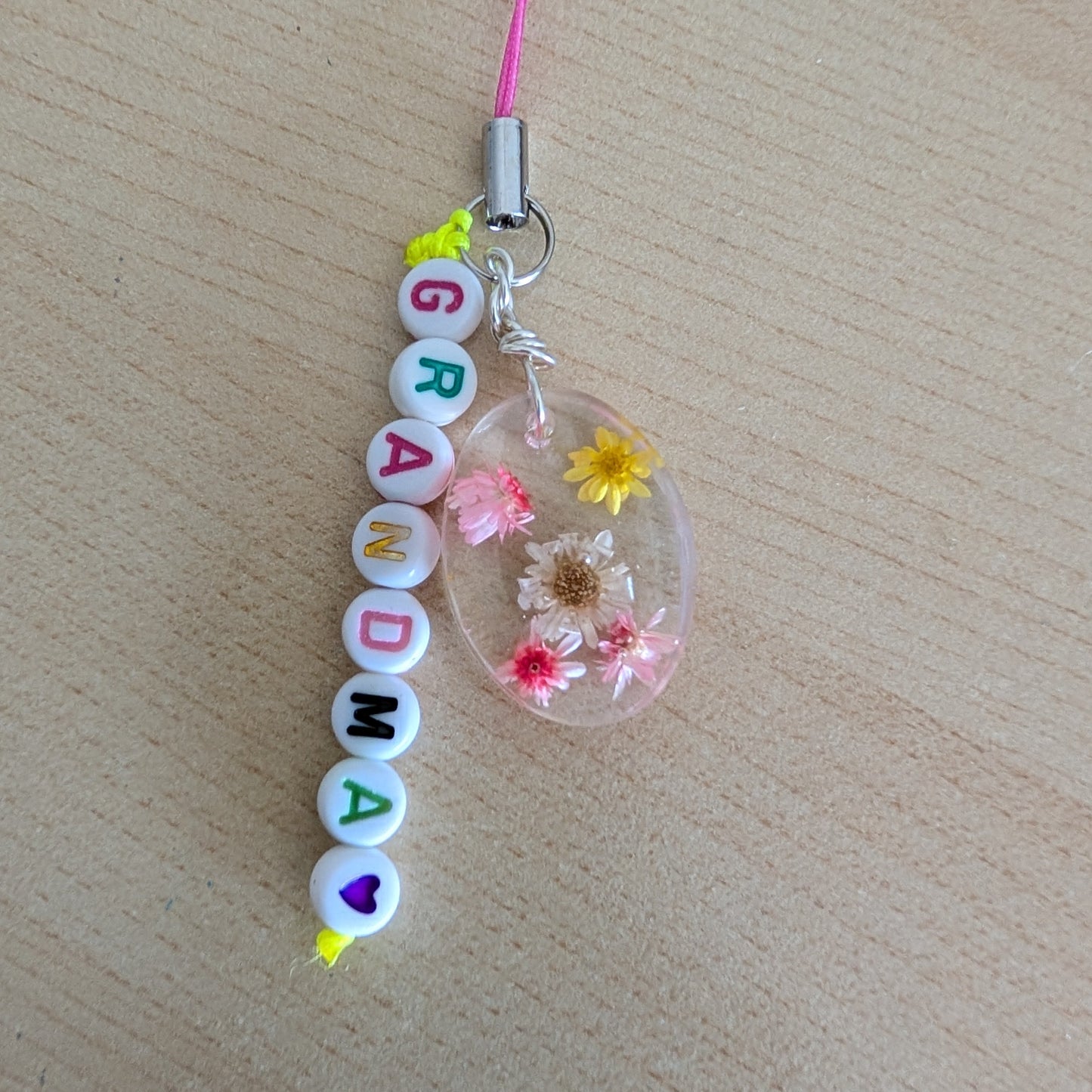 Spice up your phone with this charming resin charm, adorned with real dried flowers and beads. The 3.75 inch length adds a touch of flair to any device. (It's like a bouquet, but for your phone!)

Phone charm - Resin charm with dried flowers and beads