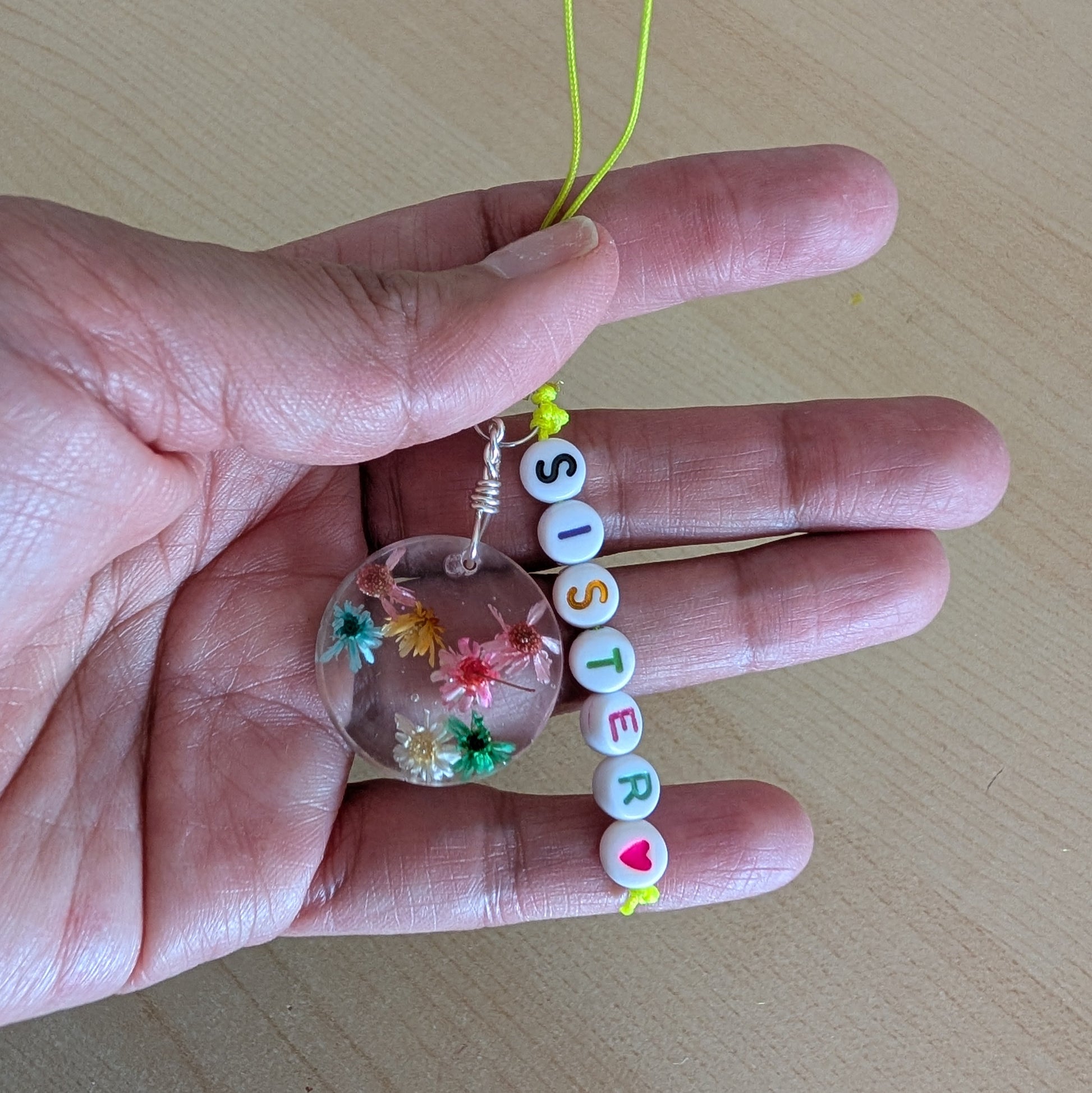 Spice up your phone with this charming resin charm, adorned with real dried flowers and beads. The 3.75 inch length adds a touch of flair to any device. (It's like a bouquet, but for your phone!)

Phone charm - Resin charm with dried flowers and beads