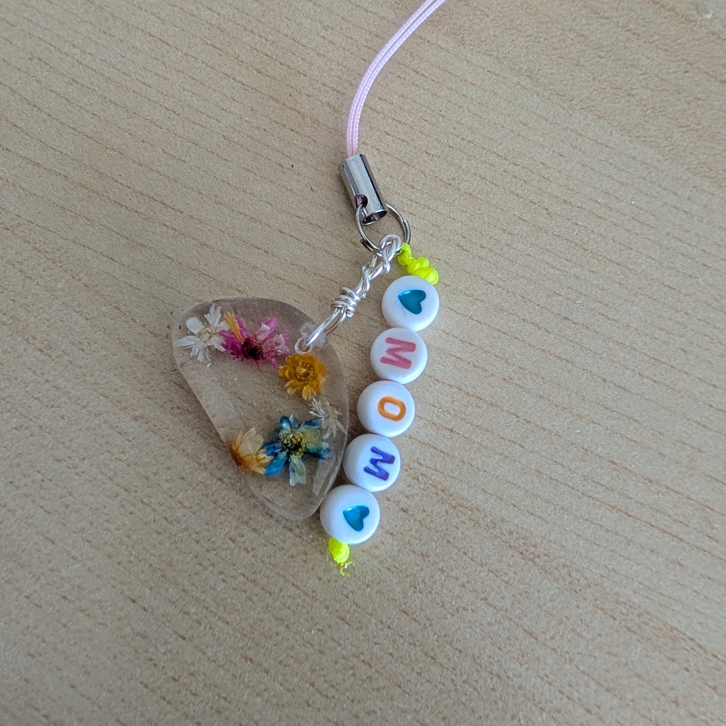 Spice up your phone with this charming resin charm, adorned with real dried flowers and beads. The 3.75 inch length adds a touch of flair to any device. (It's like a bouquet, but for your phone!)

Phone charm - Resin charm with dried flowers and beads