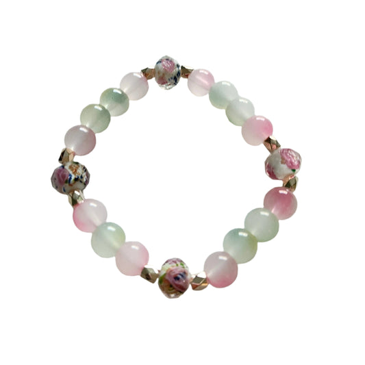 This stunning Bracelet features 9mm rose gold sand lampwork beads, complemented by 8mm pink and green glass beads. Adorned with gold rose spacer beads, the elastic design ensures a comfortable and secure fit. Elevate your style with this beautifully crafted piece.