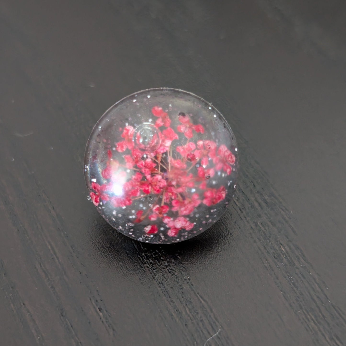 Add a touch of nature to your outfit with our Pin - 3D dried flower resin pin. The intricate design and 3D effect will surely catch everyone's eye. With the sturdy silver butterfly clutch, your pin will stay securely in place. Elevate your style with this unique and beautiful accessory.