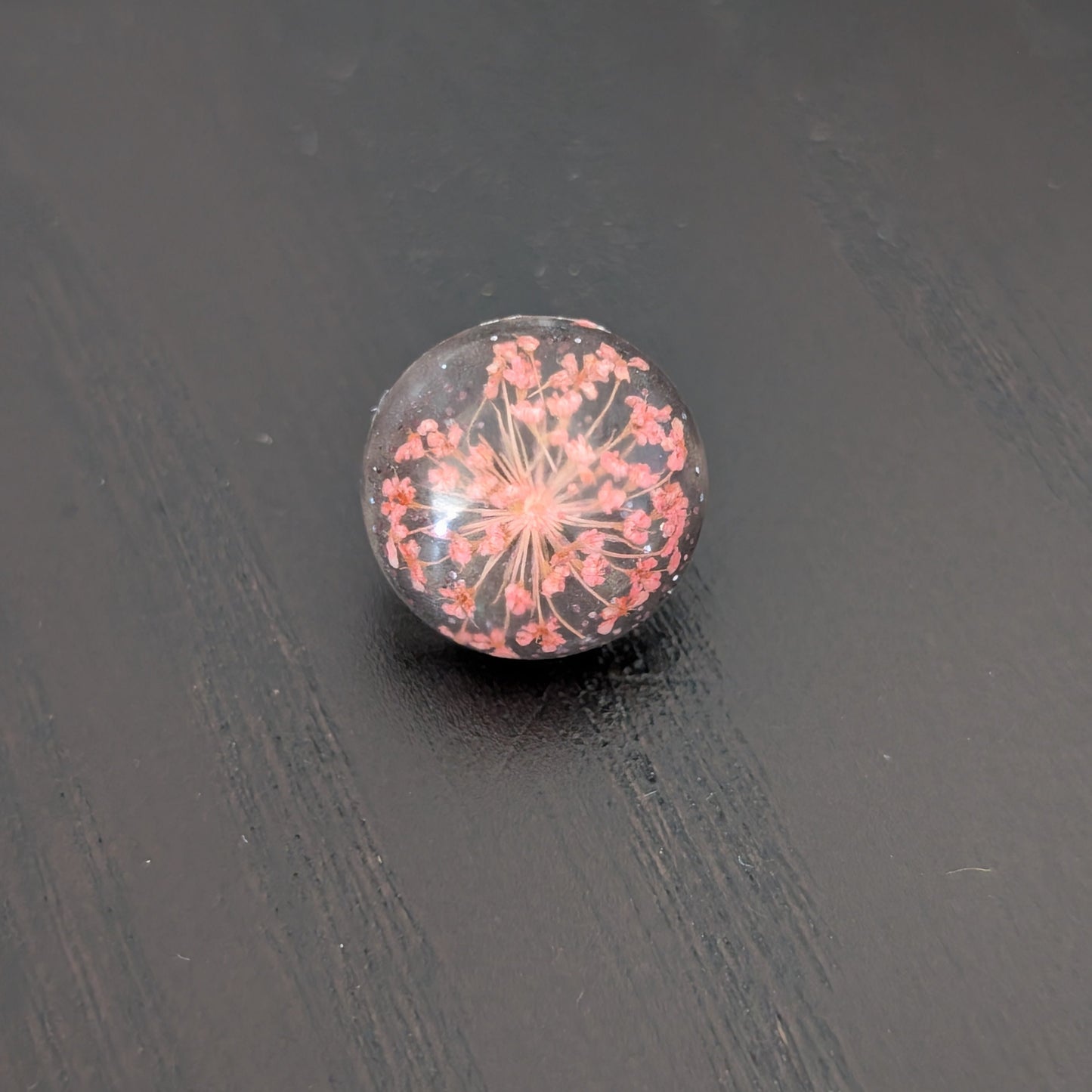 Add a touch of nature to your outfit with our Pin - 3D dried flower resin pin. The intricate design and 3D effect will surely catch everyone's eye. With the sturdy silver butterfly clutch, your pin will stay securely in place. Elevate your style with this unique and beautiful accessory.