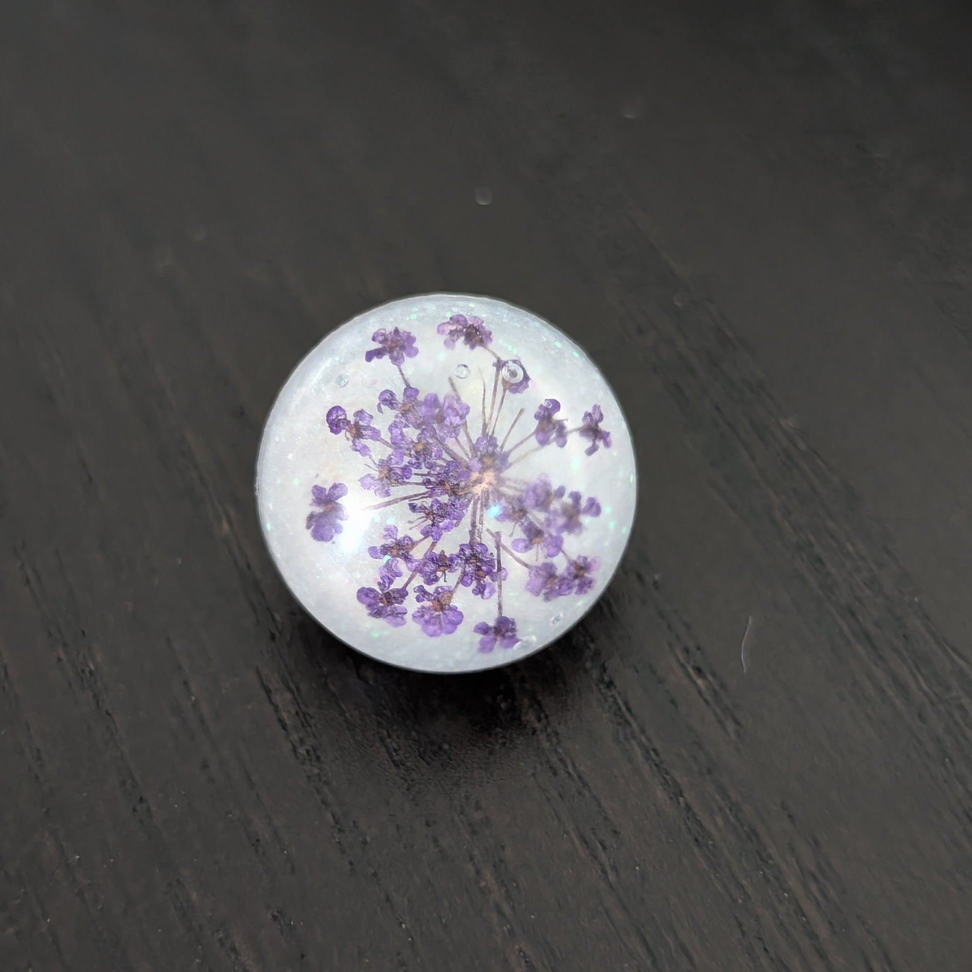 Add a touch of nature to your outfit with our Pin - 3D dried flower resin pin. The intricate design and 3D effect will surely catch everyone's eye. With the sturdy silver butterfly clutch, your pin will stay securely in place. Elevate your style with this unique and beautiful accessory.