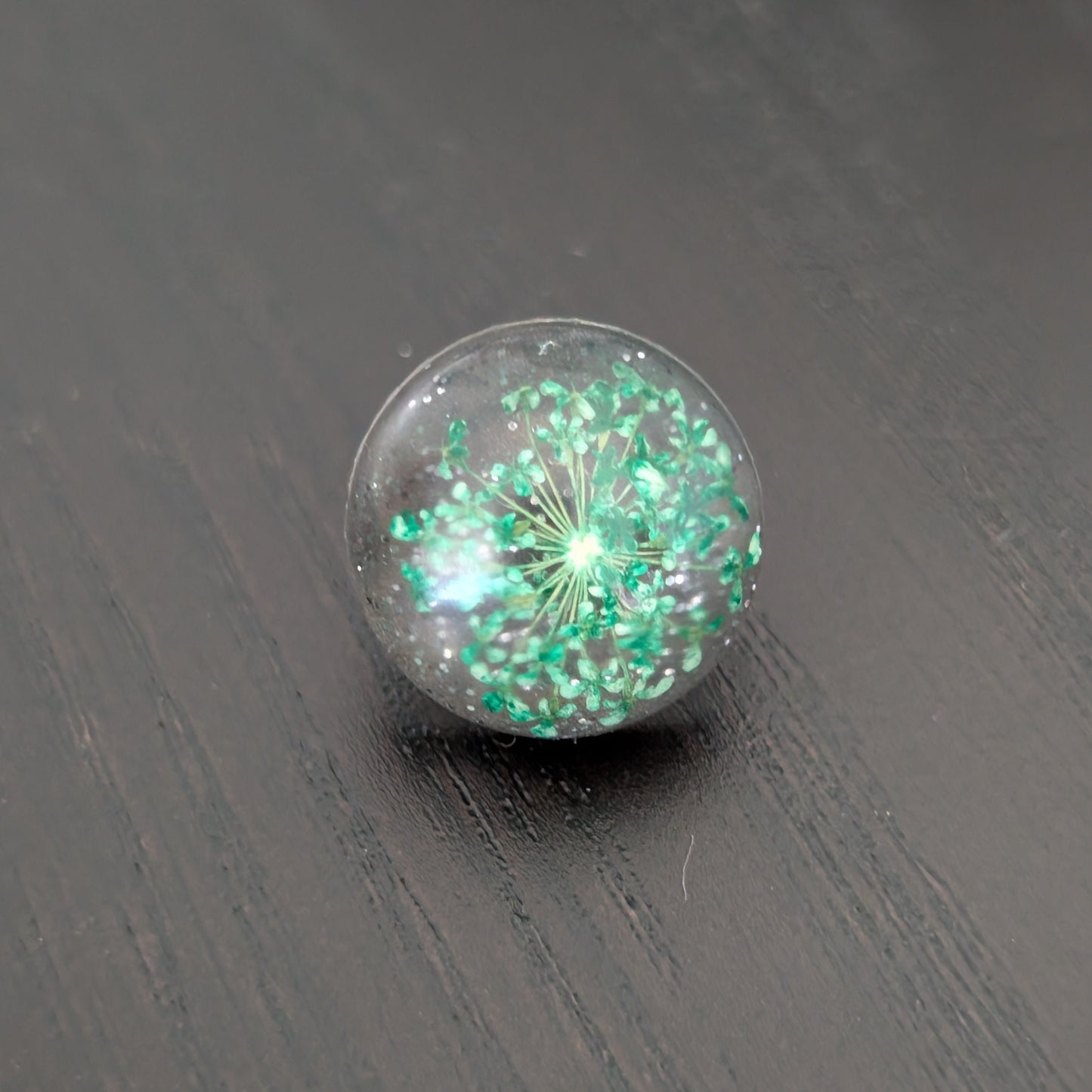 Add a touch of nature to your outfit with our Pin - 3D dried flower resin pin. The intricate design and 3D effect will surely catch everyone's eye. With the sturdy silver butterfly clutch, your pin will stay securely in place. Elevate your style with this unique and beautiful accessory.