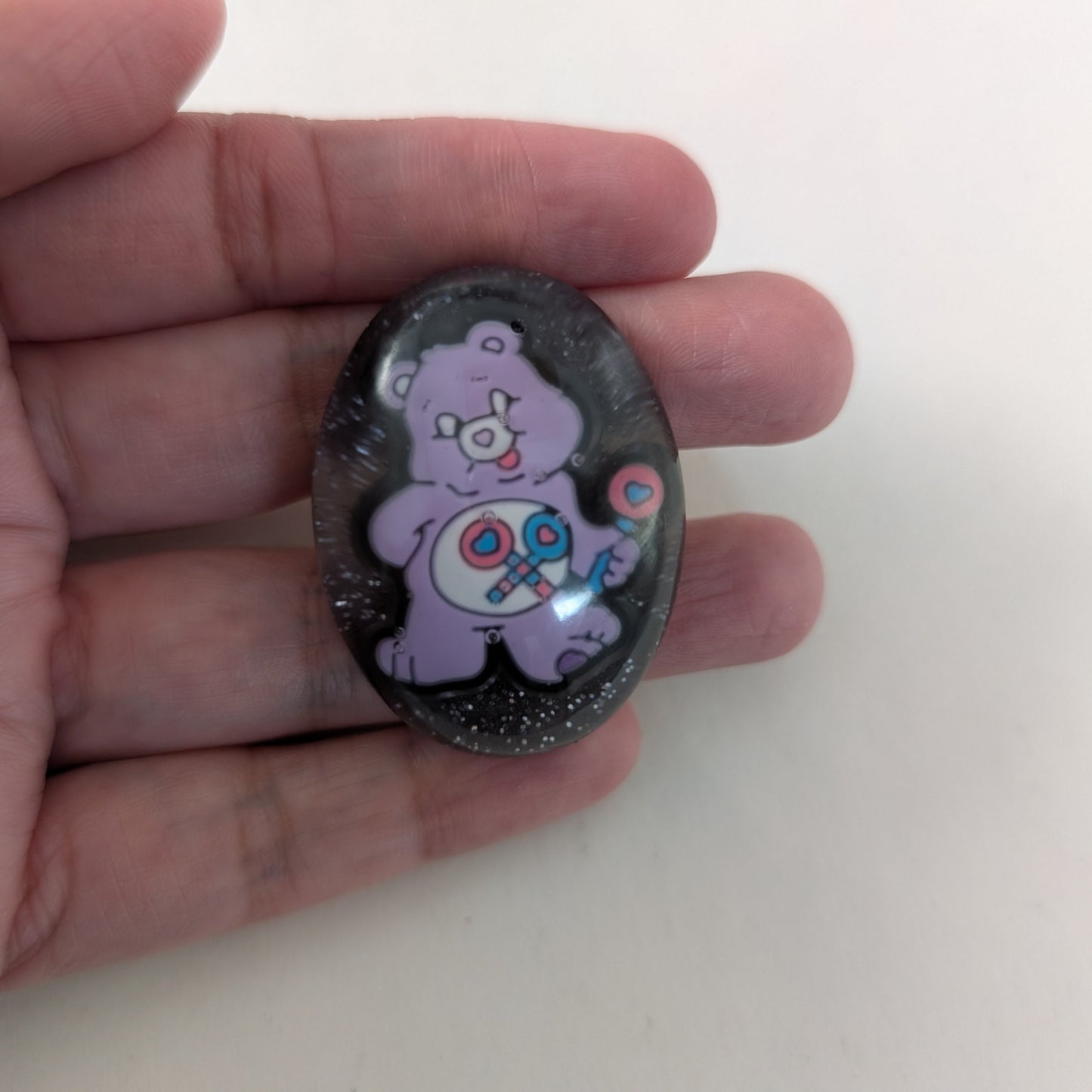This 3D Care Bears resin pin adds a playful and nostalgic touch to any outfit or accessory. Crafted with detailed resin and secured by a silver butterfly clutch, it ensures both style and durability. Perfect for collectors or fans looking to brighten their day with a charming, wearable keepsake.