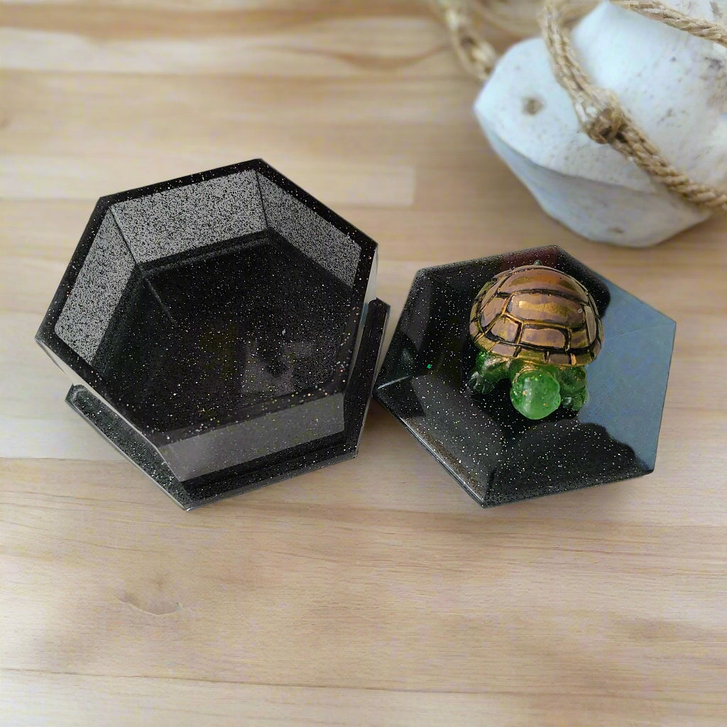 Add a playful touch to your home decor with this Knickknack! The resin hexagon trinket box features a turtle lid and is the perfect size for storing small treasures. With dimensions of 2.5 x 3 x 1 inches and weighing only 3.4 ounces, it's a quirky and lightweight addition to any room.