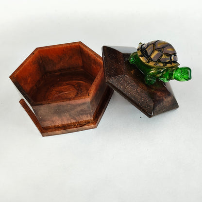 Add a playful touch to your home decor with this Knickknack! The resin hexagon trinket box features a turtle lid and is the perfect size for storing small treasures. With dimensions of 2.5 x 3 x 1 inches and weighing only 3.4 ounces, it's a quirky and lightweight addition to any room.