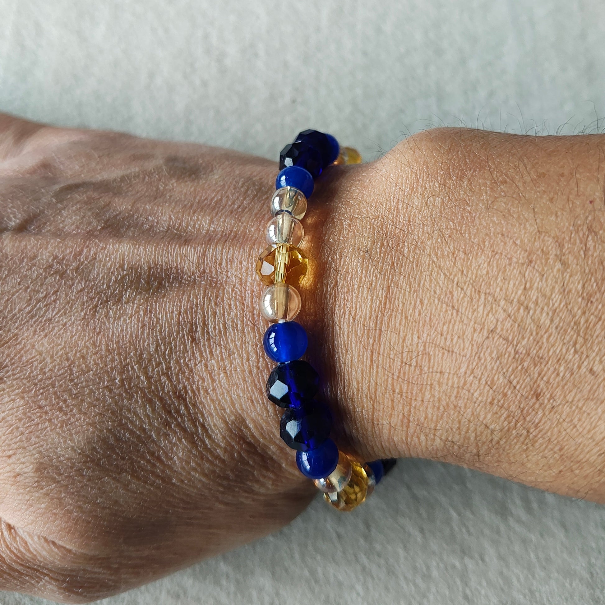 Add a touch of elegance to any outfit with our Bracelet - Elastic 6mm & 8 mm blue & gold glass beads. The elastic design ensures a comfortable fit for all wrist sizes. At a weight of just 0.38 oz, it is lightweight and easy to wear all day long. Elevate your style with this stunning bracelet.

Bracelet - Elastic 6mm & 8 mm blue & gold glass beads