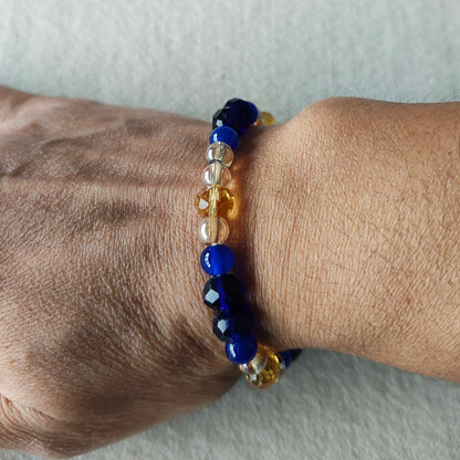 Add a touch of elegance to any outfit with our Bracelet - Elastic 6mm & 8 mm blue & gold glass beads. The elastic design ensures a comfortable fit for all wrist sizes. At a weight of just 0.38 oz, it is lightweight and easy to wear all day long. Elevate your style with this stunning bracelet.

Bracelet - Elastic 6mm & 8 mm blue & gold glass beads