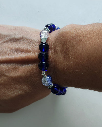 Elevate your style with our 8mm navy and blue crackle glass bead bracelet, adorned with silver spacer beads. The elastic band ensures a comfortable fit. Perfect for adding a touch of elegance to any outfit. Make a statement with this stunning accessory.