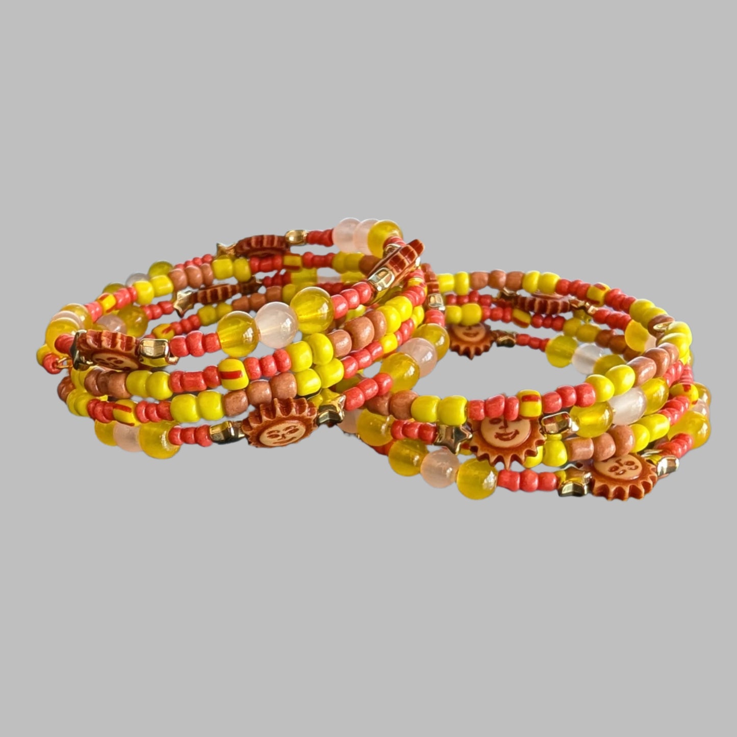 This vibrant memory wire bracelet features four coils adorned with yellow and sun beads, complemented by yellow, tan, and orange spacer beads. Its flexible design ensures a comfortable fit for any wrist size, making it an eye-catching accessory that brightens your look with warm, sunny hues. Perfect for adding a splash of color and effortless style to your everyday outfits.