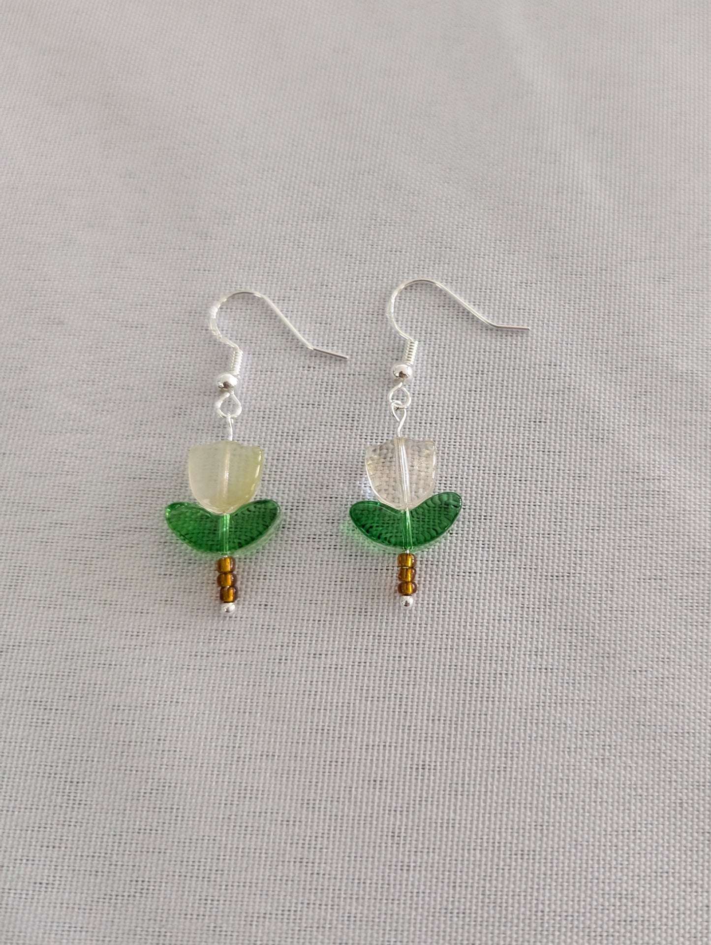 Delicate crystal and seed beads form an enchanting flower design, suspended from hypoallergenic 925 sterling silver hooks. These lightweight earrings measure just 1.5 inches, making them perfect for everyday elegance or layering with other pieces. At only 0.1 oz, they're comfortable enough to wear all day without fatigue. The shimmering bead work catches light beautifully, adding a touch of sparkle and sophistication to any outfit. Ideal for those who appreciate handcrafted jewelry with timeless appeal.