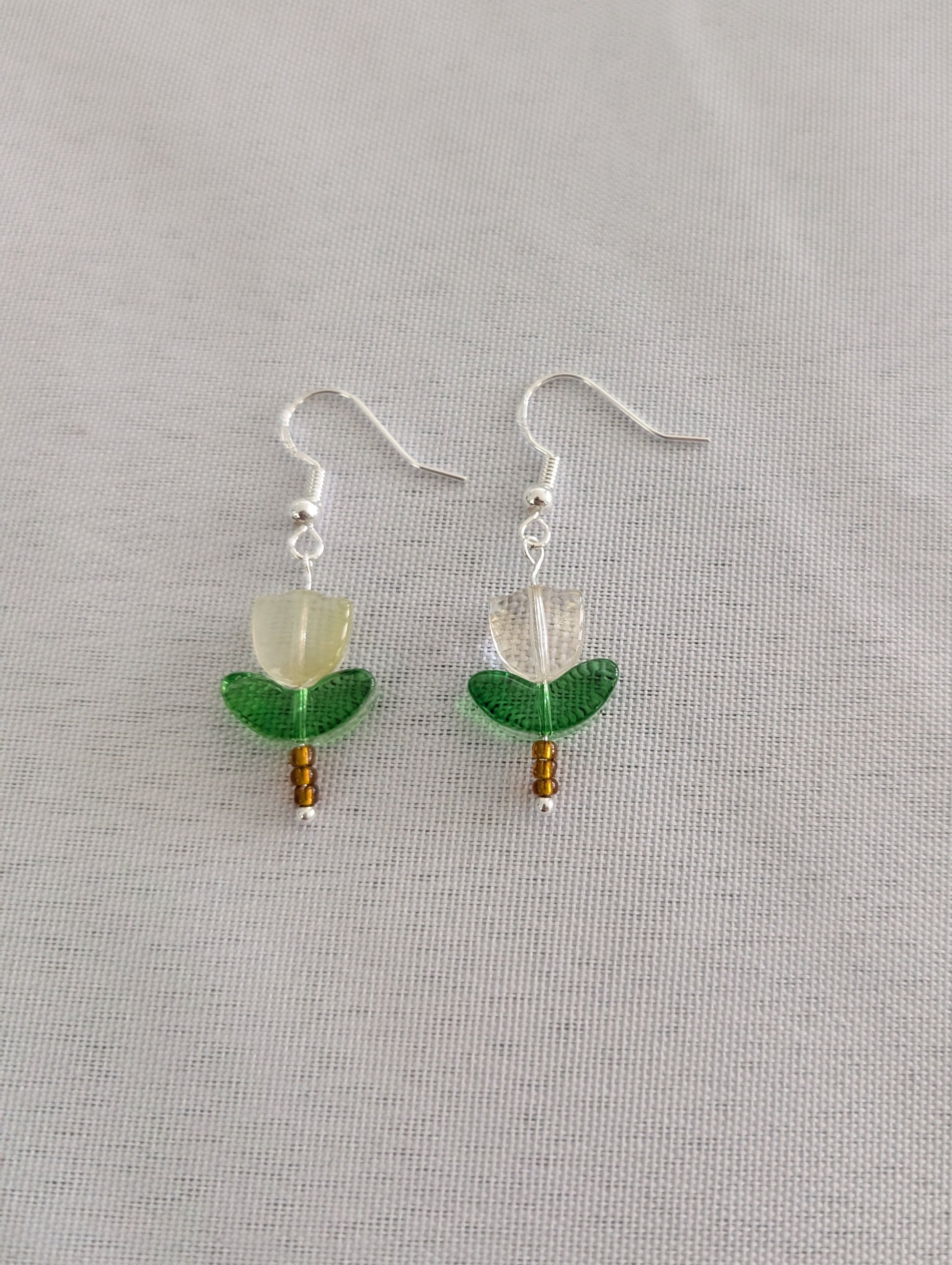 Delicate crystal and seed beads form an enchanting flower design, suspended from hypoallergenic 925 sterling silver hooks. These lightweight earrings measure just 1.5 inches, making them perfect for everyday elegance or layering with other pieces. At only 0.1 oz, they're comfortable enough to wear all day without fatigue. The shimmering bead work catches light beautifully, adding a touch of sparkle and sophistication to any outfit. Ideal for those who appreciate handcrafted jewelry with timeless appeal.