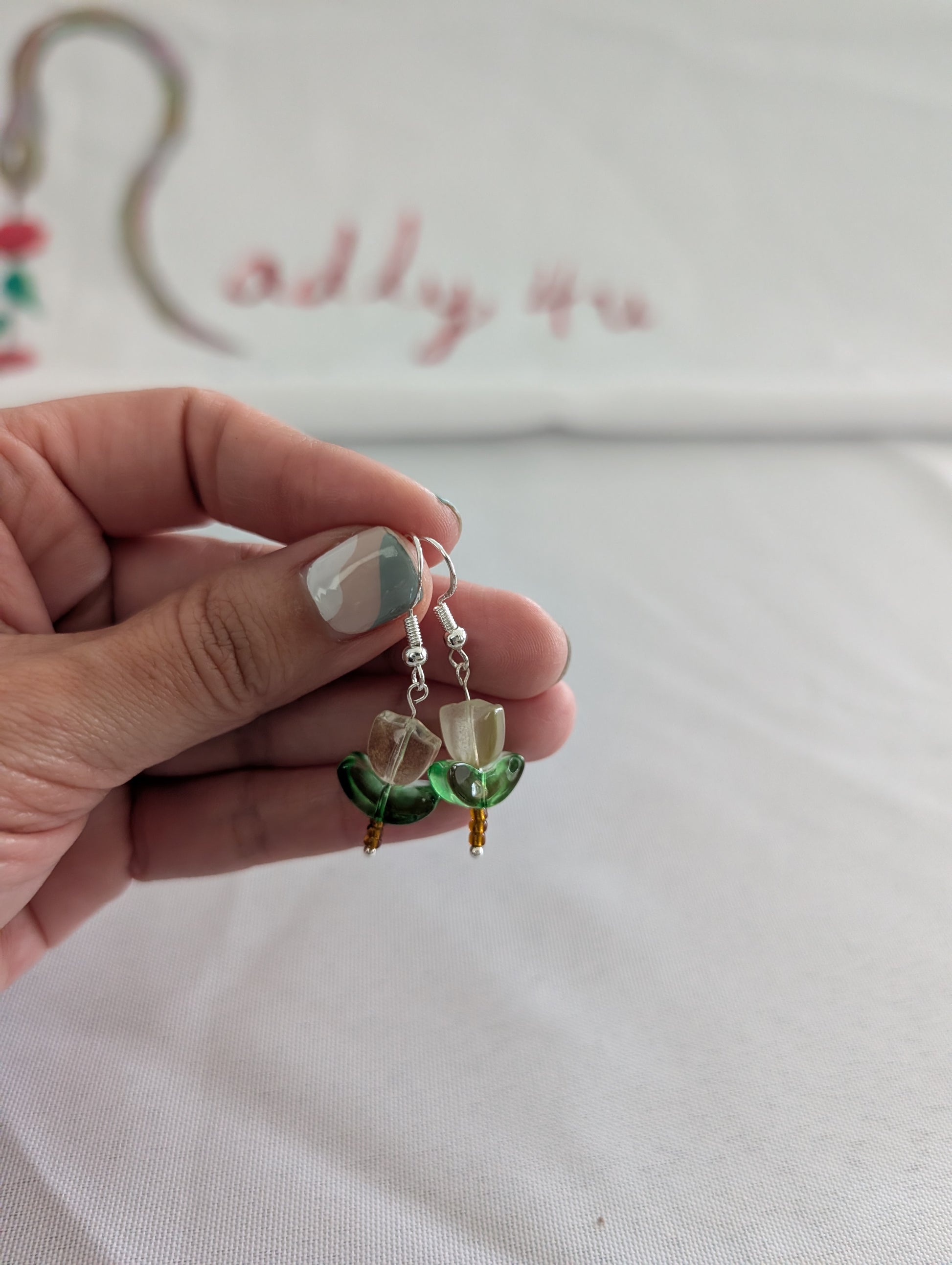 Delicate crystal and seed beads form an enchanting flower design, suspended from hypoallergenic 925 sterling silver hooks. These lightweight earrings measure just 1.5 inches, making them perfect for everyday elegance or layering with other pieces. At only 0.1 oz, they're comfortable enough to wear all day without fatigue. The shimmering bead work catches light beautifully, adding a touch of sparkle and sophistication to any outfit. Ideal for those who appreciate handcrafted jewelry with timeless appeal.