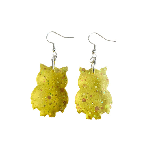 Add a whimsical touch to your outfit with these earrings featuring a resin owl on a hook. Stand out from the crowd with this unique and eye-catching accessory. Perfect for adding a playful and charming element to any look.