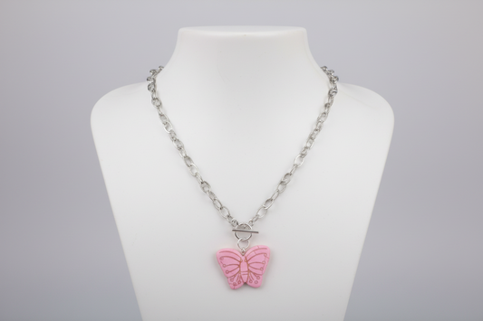 Necklace with a pink butterfly pendant on a mannequin bust against a gray background