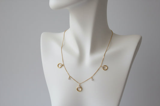 A stainless steel gold chain necklace with moons and rhinestones, 18 inches long.