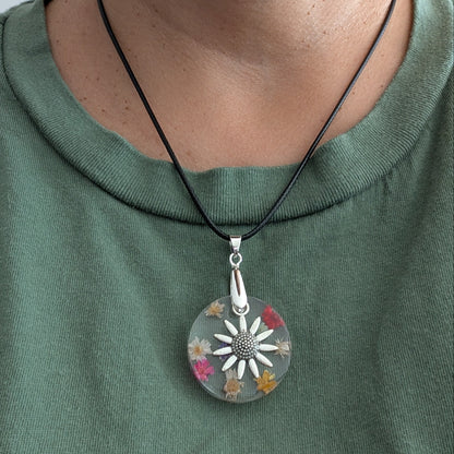 Necklace - 17.5 inches resin circle with flowers and silver flower charm on black leather cord with clasp