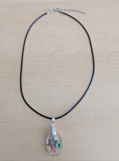 Necklace - 17.5 inches resin oval with flowers and silver flower charm on black leather cord with clasp