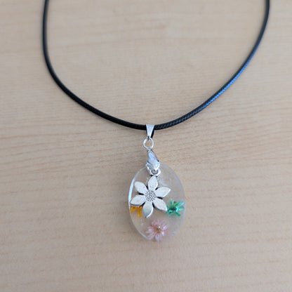 Necklace - 17.5 inches resin oval with flowers and silver flower charm on black leather cord with clasp