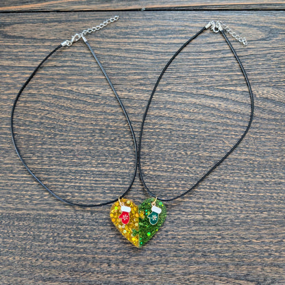 Necklace - 17.5 inches black waxed cord with two resin half hearts and a Christmas charm