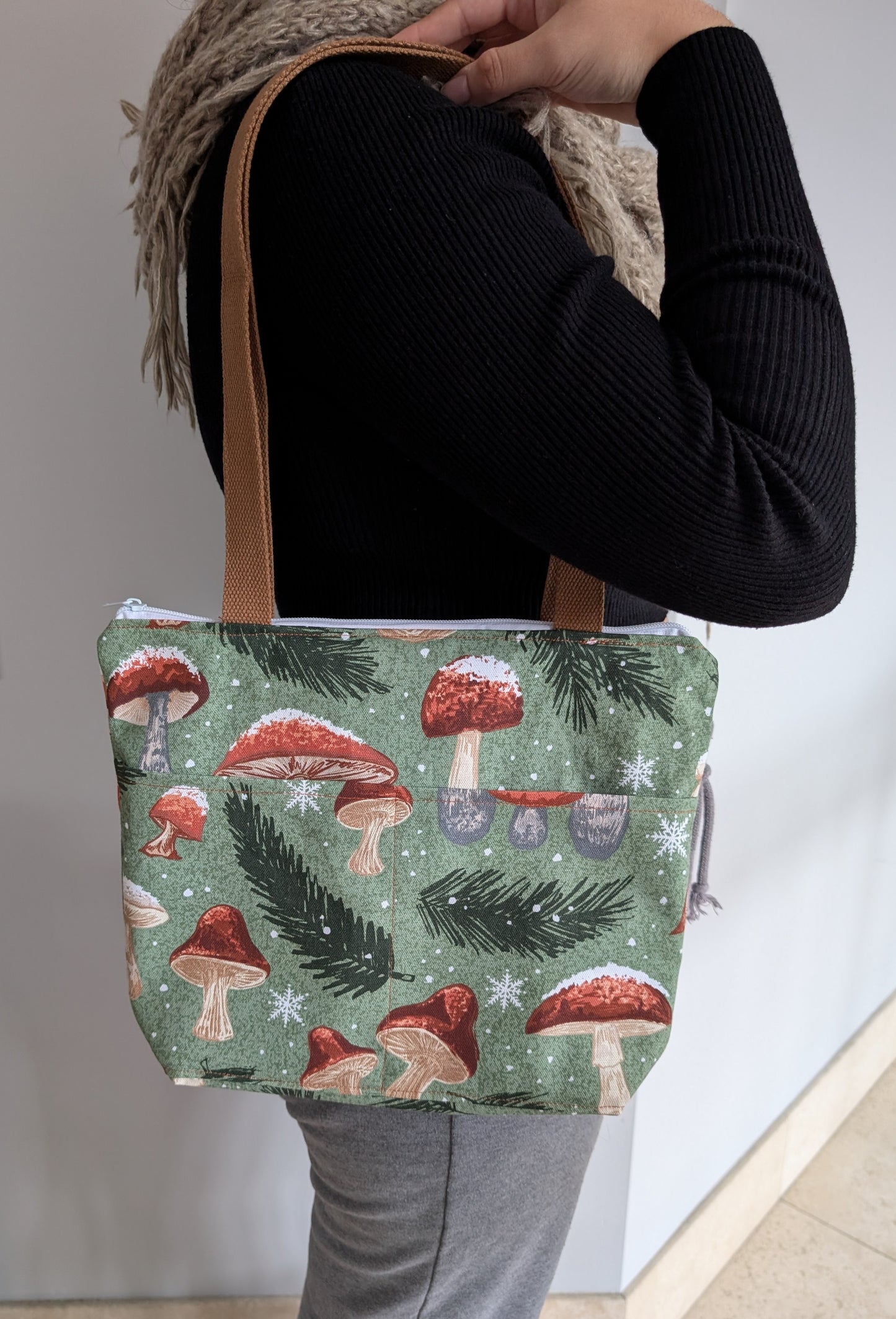 Snowy Mushrooms bag with orange lining two outer pockets one inner pocket and a zipper closure