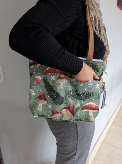 Snowy Mushrooms bag with orange lining two outer pockets one inner pocket and a zipper closure