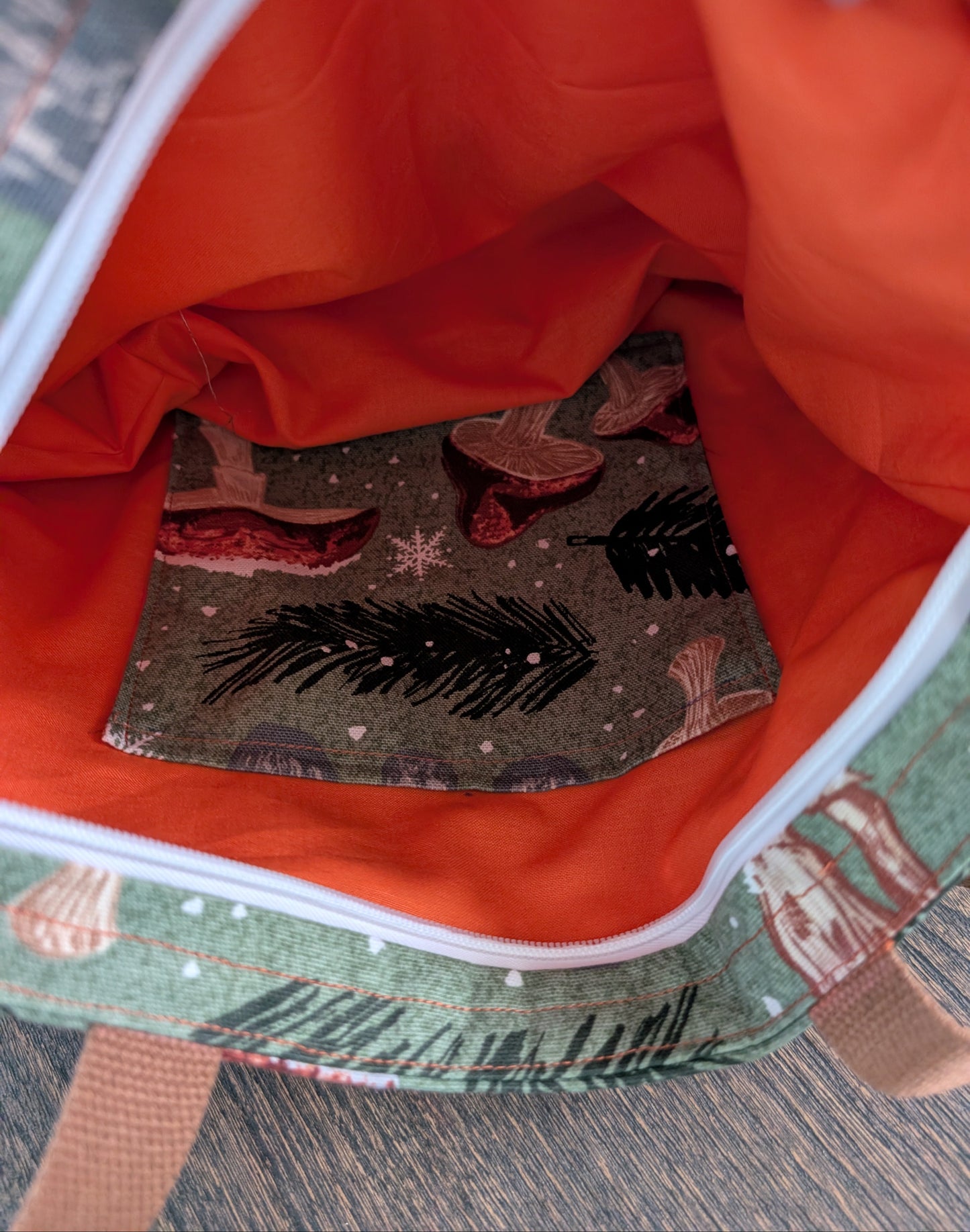 Snowy Mushrooms bag with orange lining one inner pocket and zipper closure