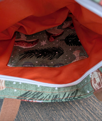 Snowy Mushrooms bag with orange lining one inner pocket and zipper closure