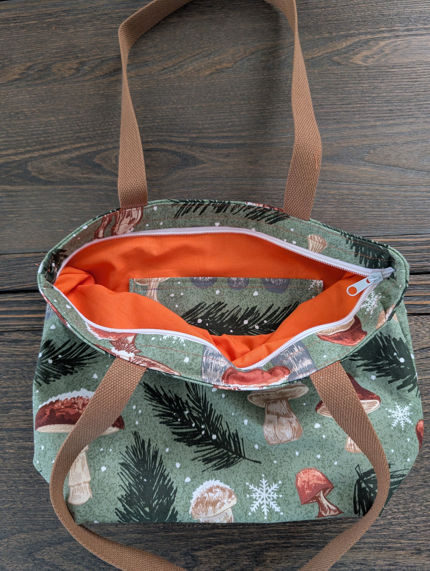 Snowy Mushrooms bag with orange lining one inner pocket and zipper closure
