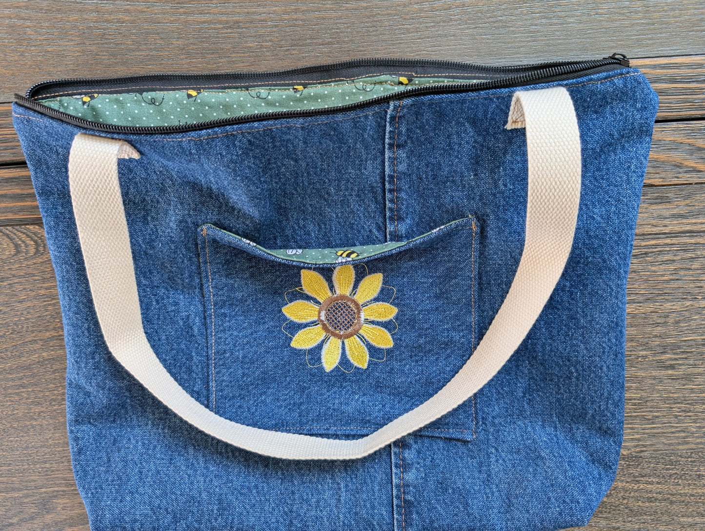Jean tote bag with bees on green dots lining one outer pocket one inner pocket and zipper closure