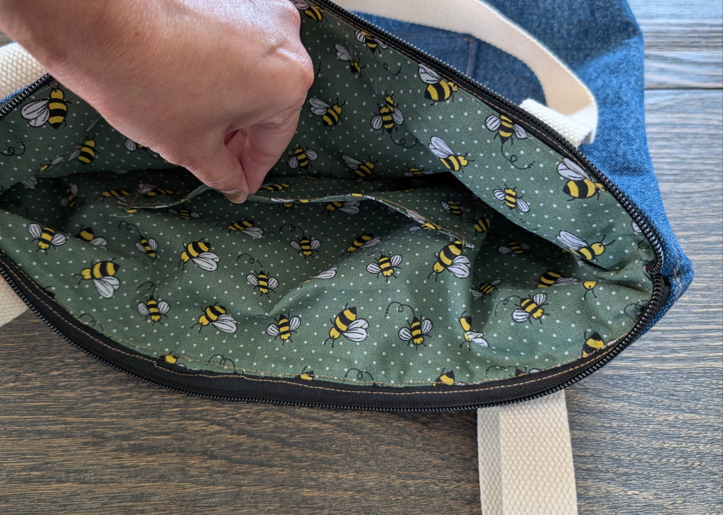 Jean tote bag with bees on green dots lining one outer pocket one inner pocket and zipper closure