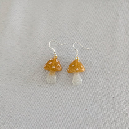 Mushroom-shaped earrings on a light gray background