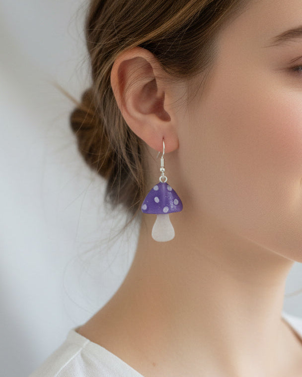 Close-up of a person wearing a purple and white mushroom earring.