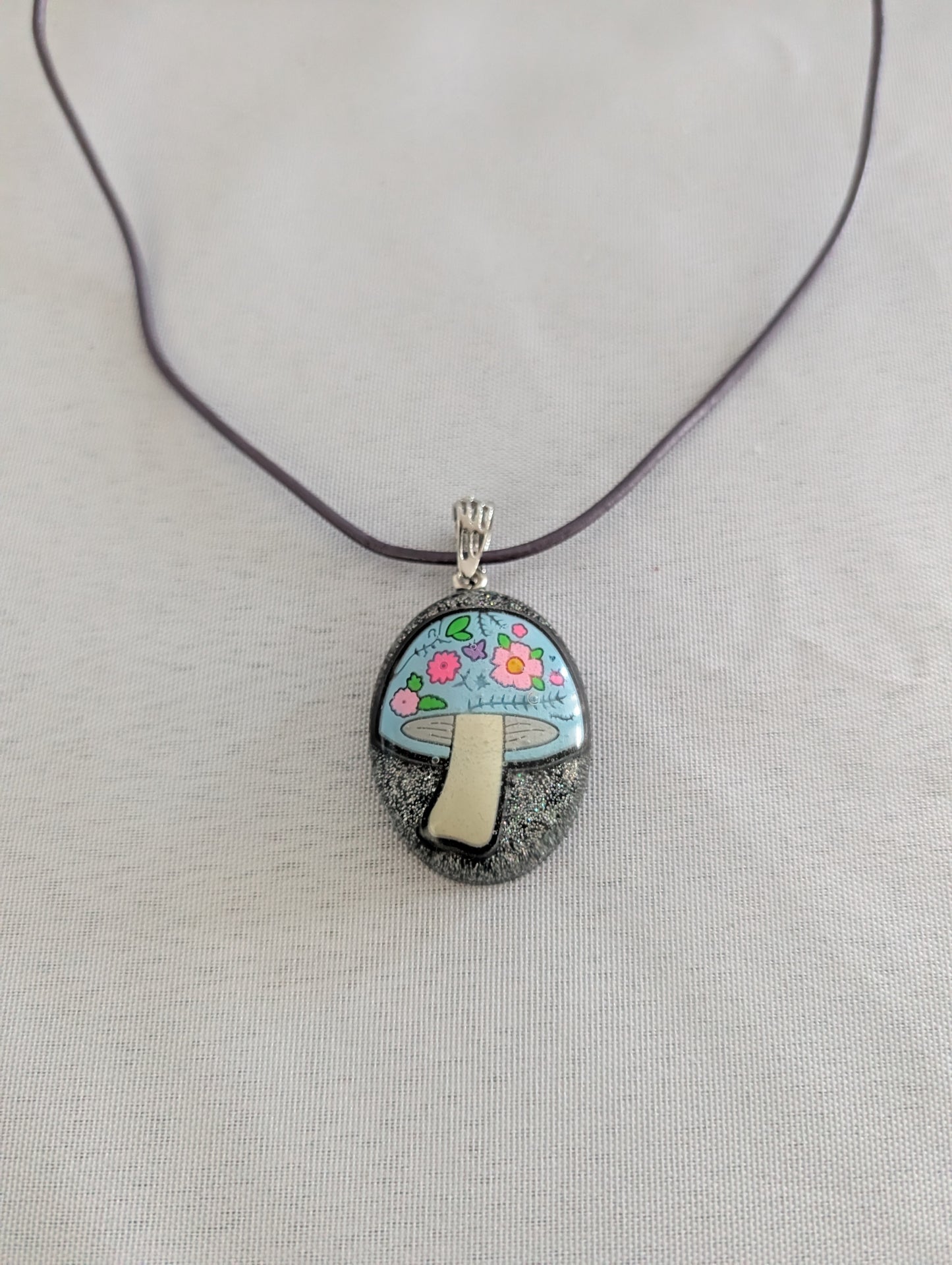 Pendant necklace with a mushroom design on a gray background