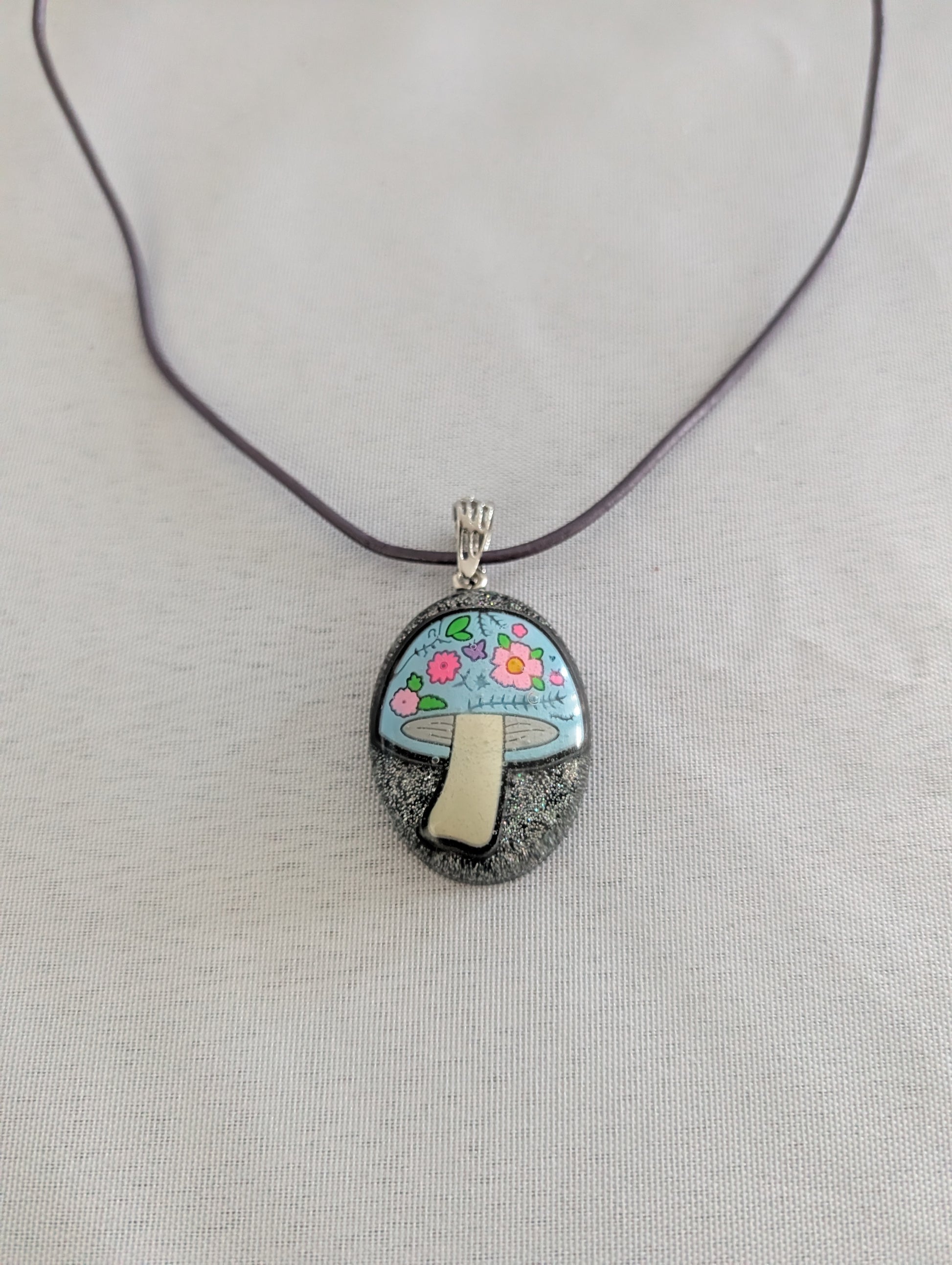 Pendant necklace with a mushroom design on a gray background