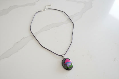 Necklace with a pendant featuring a mushroom design on a light gray background